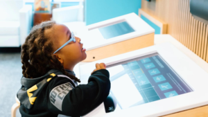 girl playing with dance coding exhibit in By Design